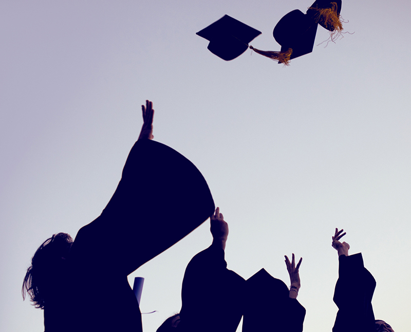 Graduating students throwing their caps in the air
